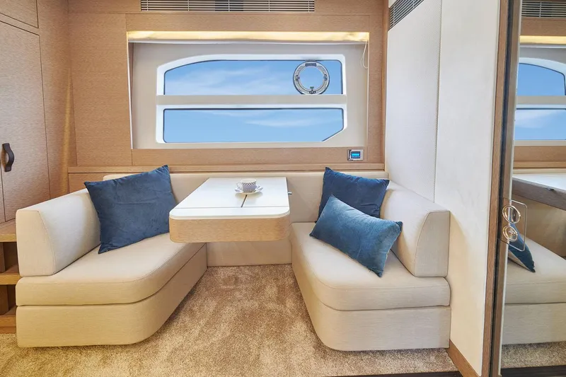  Yacht Photos Pics Manufacturer Provided Image: Luxurious interior of 2024 Prestige 590 yacht with elegant seating and blue cushions.