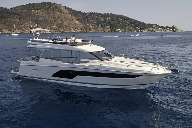  Yacht Photos Pics Manufacturer Provided Image: 2024 Prestige 590 yacht cruising on blue ocean near scenic coastline.