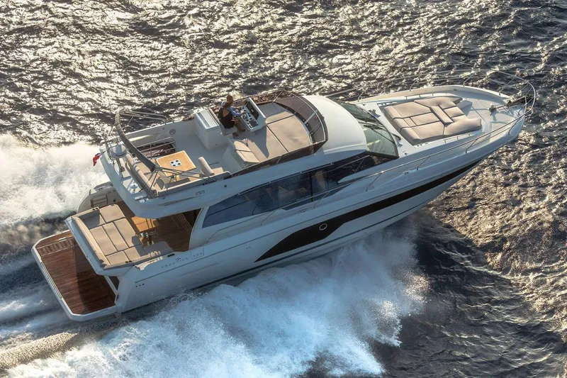  Yacht Photos Pics Manufacturer Provided Image: Luxurious 2024 Prestige 590 yacht cruising on open water, aerial view.