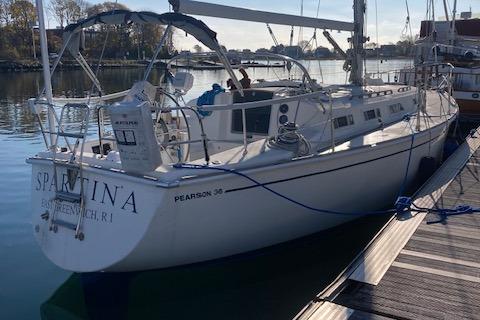 1985 Pearson 36-2 sailboat docked, named "Spartina," in calm marina waters.