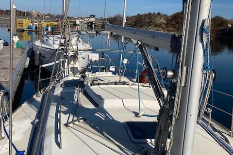 1985 Pearson 36-2 sailboat docked in a marina, surrounded by calm water and other boats.