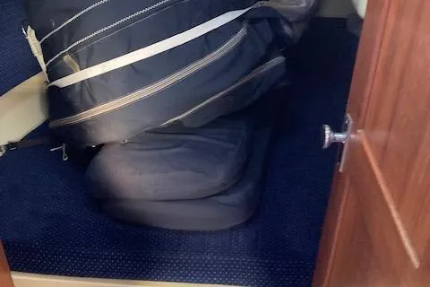 Sail storage area inside a 1985 Pearson 36-2 yacht with blue carpet.