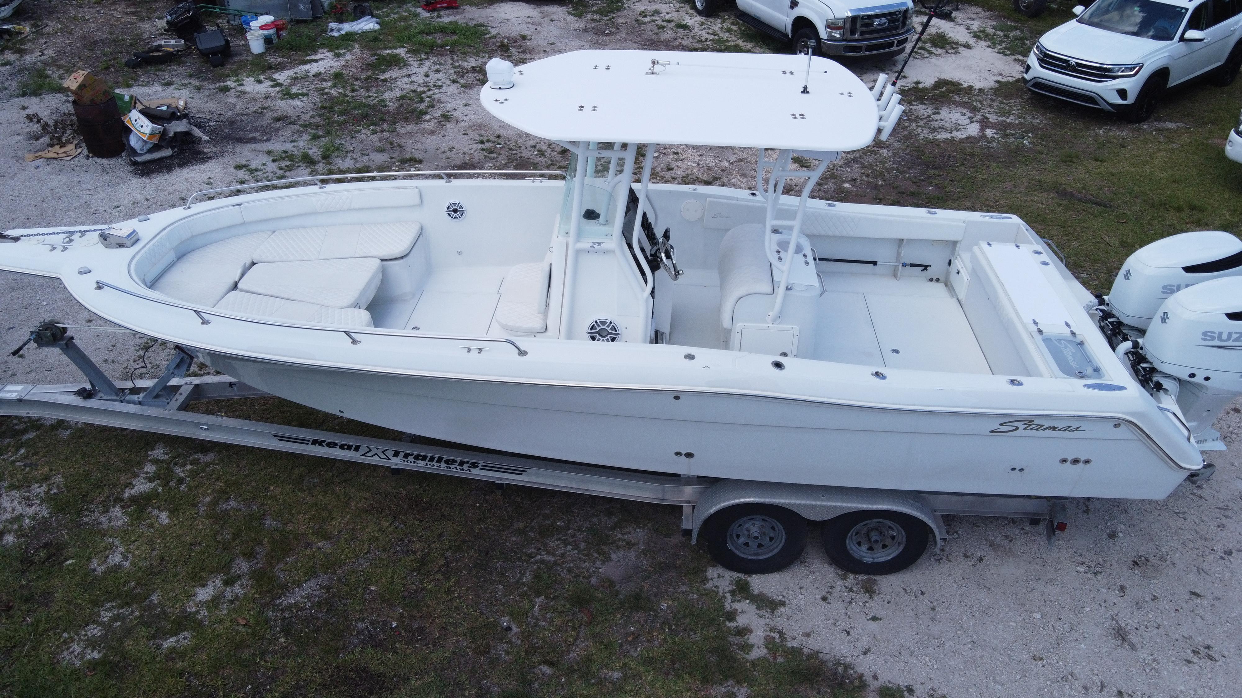 1997 Stamas 290 Tarpon boat on trailer, white exterior, parked outdoors.