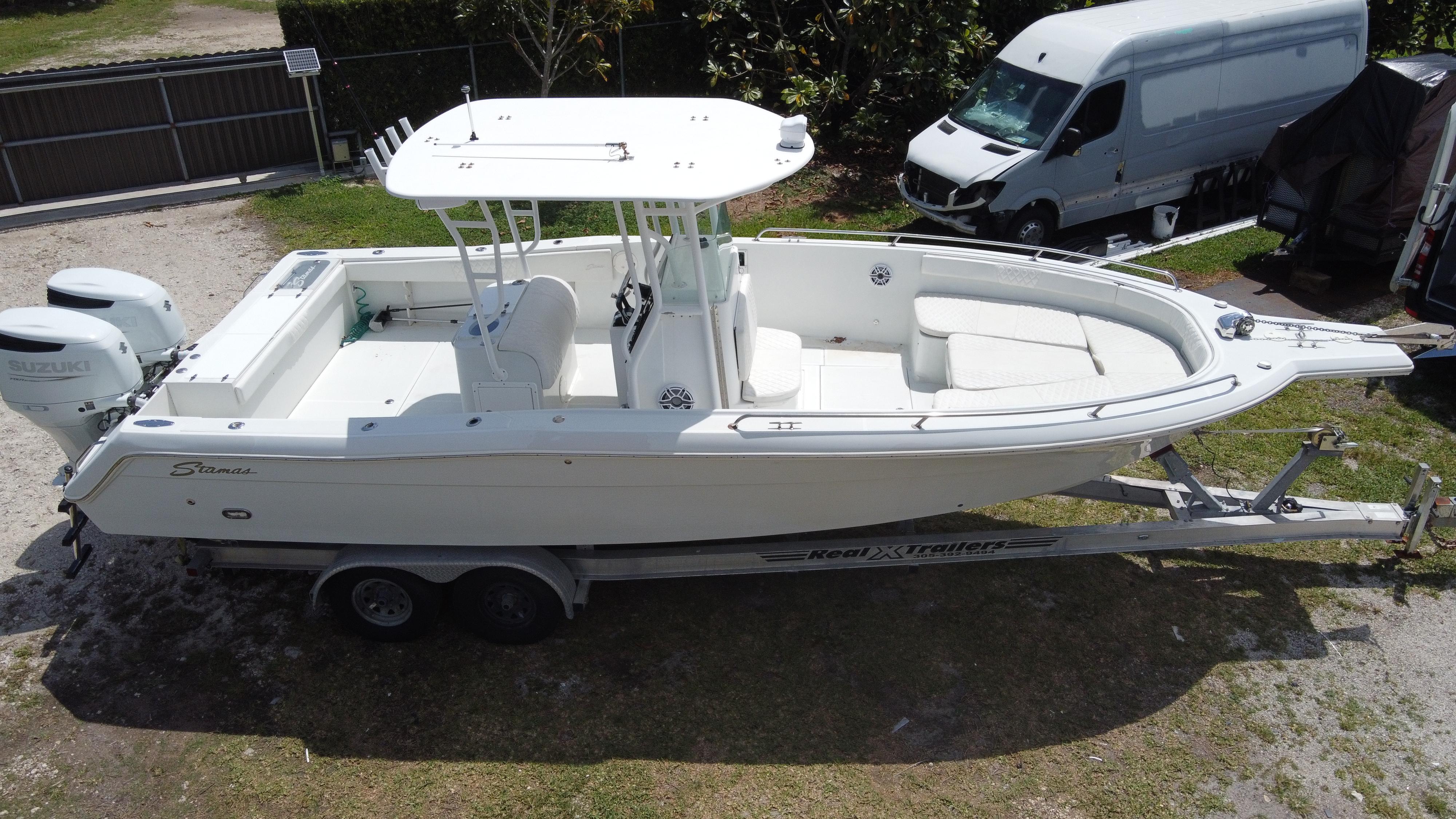 1997 Stamas 290 Tarpon boat on trailer, parked outdoors, with twin engines.
