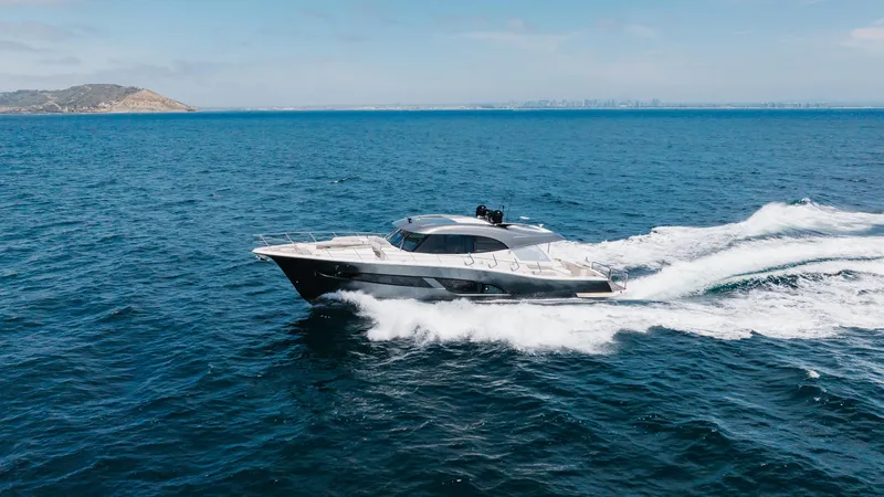 Hermosa Yacht Photos Pics 2022 Riviera 645 SUV cruising on open sea under clear skies.