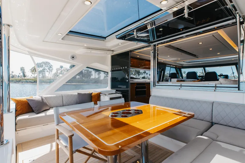 Hermosa Yacht Photos Pics Luxurious interior of 2022 Riviera 645 SUV yacht with elegant seating and dining area.