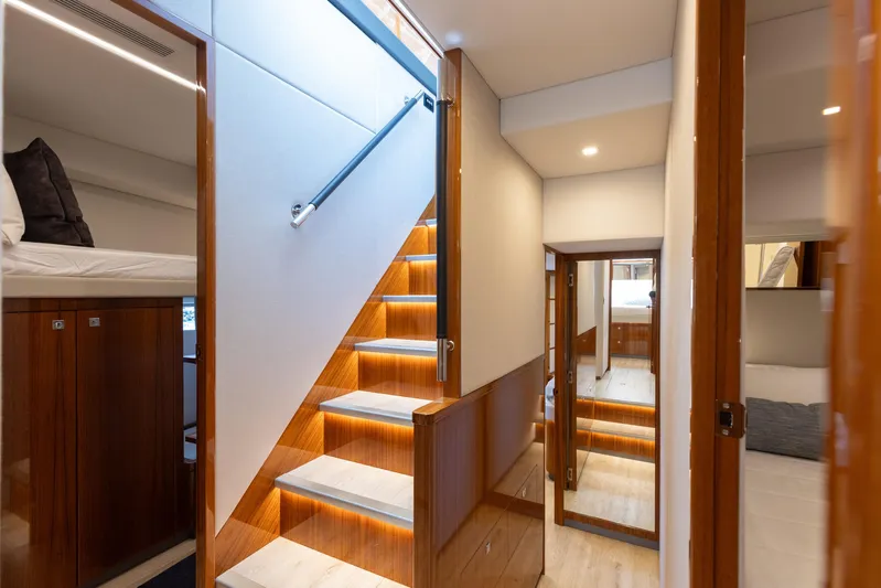 Hermosa Yacht Photos Pics Interior of 2022 Riviera 645 SUV yacht with modern staircase and elegant wood finishes.