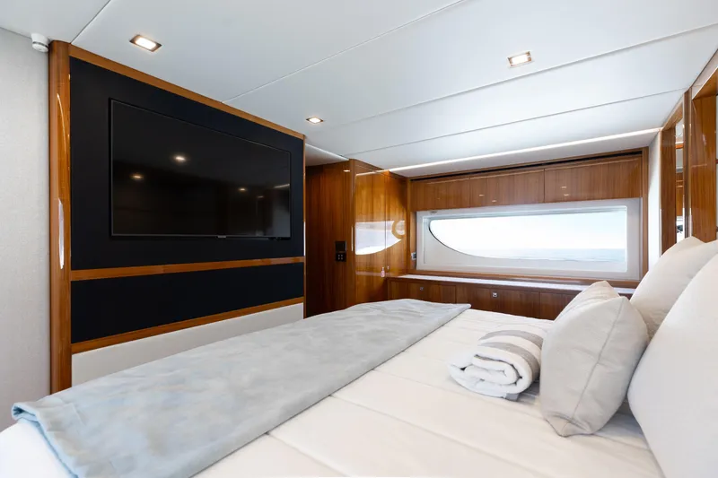 Hermosa Yacht Photos Pics Luxurious bedroom interior of 2022 Riviera 645 SUV yacht with large window and TV.