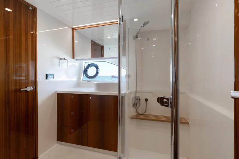 Hermosa Yacht Photos Pics Luxurious bathroom in 2022 Riviera 645 SUV yacht with wood accents and modern fixtures.