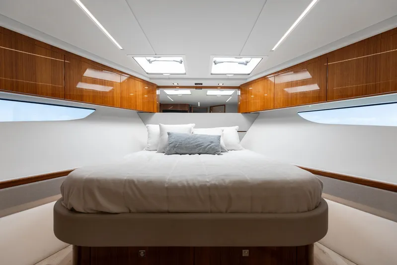 Hermosa Yacht Photos Pics Luxurious bedroom interior of 2022 Riviera 645 SUV yacht with elegant wood finishes.