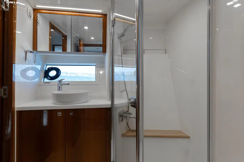 Hermosa Yacht Photos Pics Luxurious bathroom in 2022 Riviera 645 SUV yacht with modern fixtures and wooden accents.