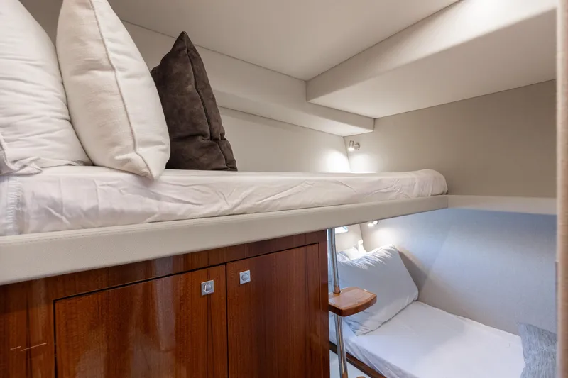 Hermosa Yacht Photos Pics 2022 Riviera 645 SUV yacht interior with cozy bunk beds and wooden cabinetry.