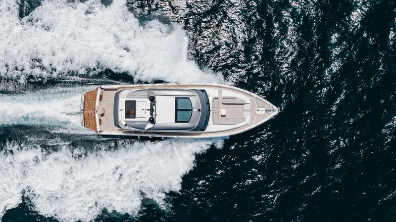 Hermosa Yacht Photos Pics Aerial view of 2022 Riviera 645 SUV yacht cruising through ocean waves.