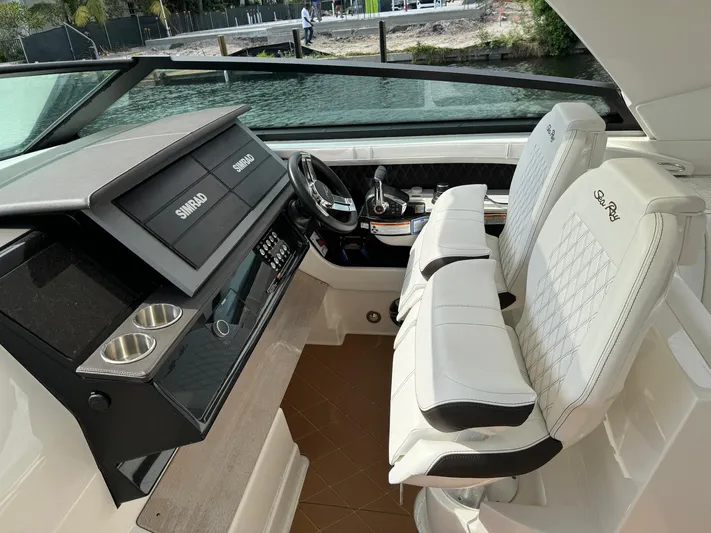 Kelly's Buoys Yacht Photos Pics 2021 Sea Ray 400 SLX OB boat cockpit with dual white seats and modern dashboard.