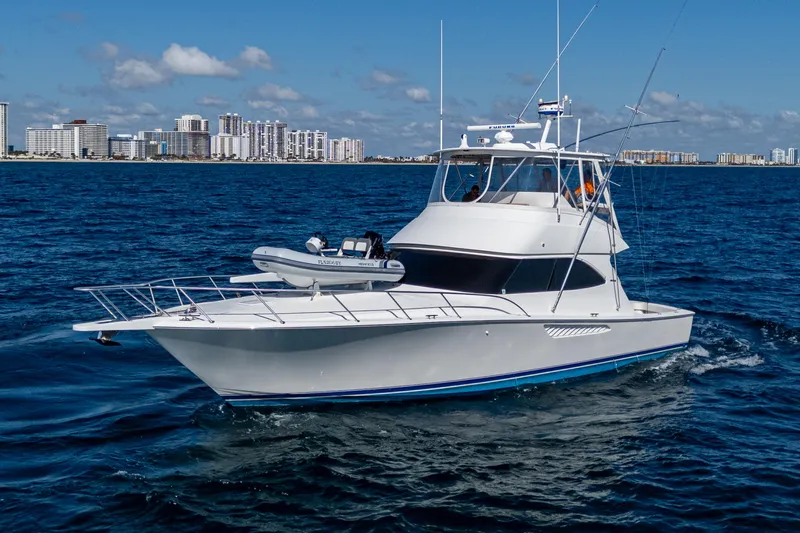 Blind Date Yacht Photos Pics 2016 Viking 46 Convertible yacht cruising on open water with city skyline backdrop.