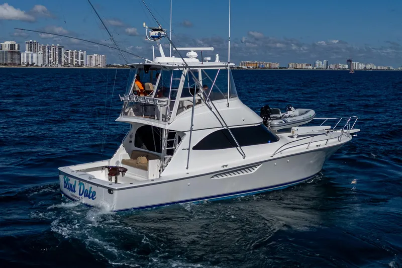 Blind Date Yacht Photos Pics 2016 Viking 46 Convertible yacht cruising on open water, city skyline in background.