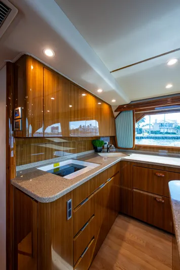 Blind Date Yacht Photos Pics Luxurious kitchen interior of 2016 Viking 46 Convertible yacht with wood cabinetry and modern appliances.