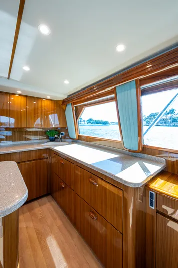 Blind Date Yacht Photos Pics Luxurious interior of 2016 Viking 46 Convertible yacht with wooden cabinetry and large windows.