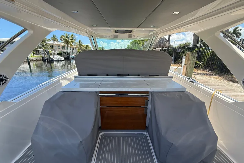  Yacht Photos Pics 2019 Tiara Sport 38 LS boat interior with covered seating and cabinetry, dockside view.