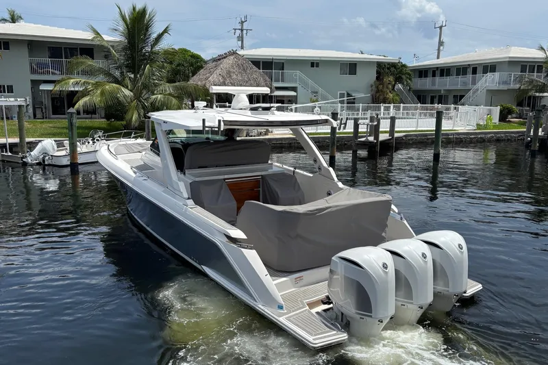  Yacht Photos Pics 2019 Tiara Sport 38 LS boat with triple outboard engines docked in a marina.
