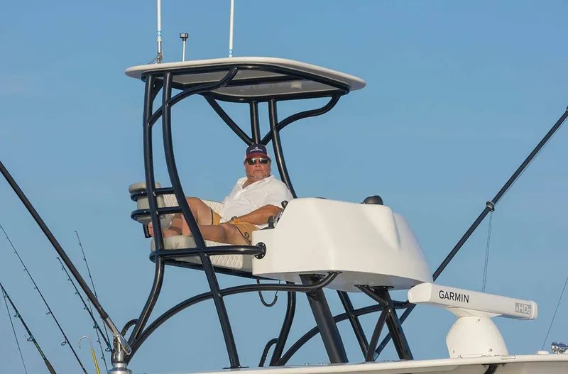  Yacht Photos Pics Man relaxing on a 2025 Regulator 41 CC boat with fishing rods.