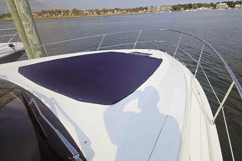 Sea Czar Yacht Photos Pics 2015 Fairline Targa 48 GT yacht bow with sunpad, docked by calm waters.