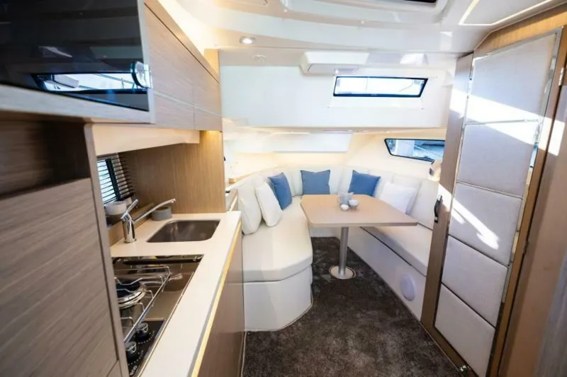  Yacht Photos Pics 2024 Jeanneau 10.5 WALK interior with modern kitchen and cozy seating area.