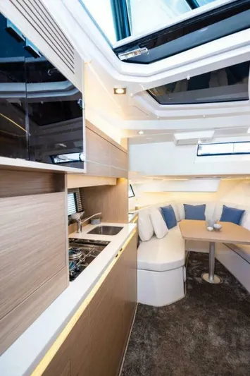  Yacht Photos Pics 2024 Jeanneau 10.5 WALK interior with modern kitchen and cozy seating area.