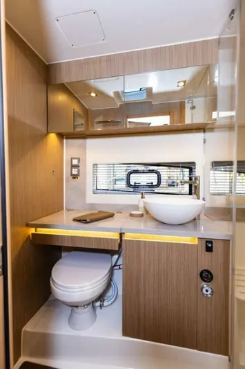  Yacht Photos Pics 2024 Jeanneau 10.5 WALK bathroom with modern fixtures and wooden cabinetry.