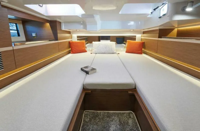  Yacht Photos Pics 2024 Jeanneau 10.5 WALK cabin interior with modern design and cozy bedding.