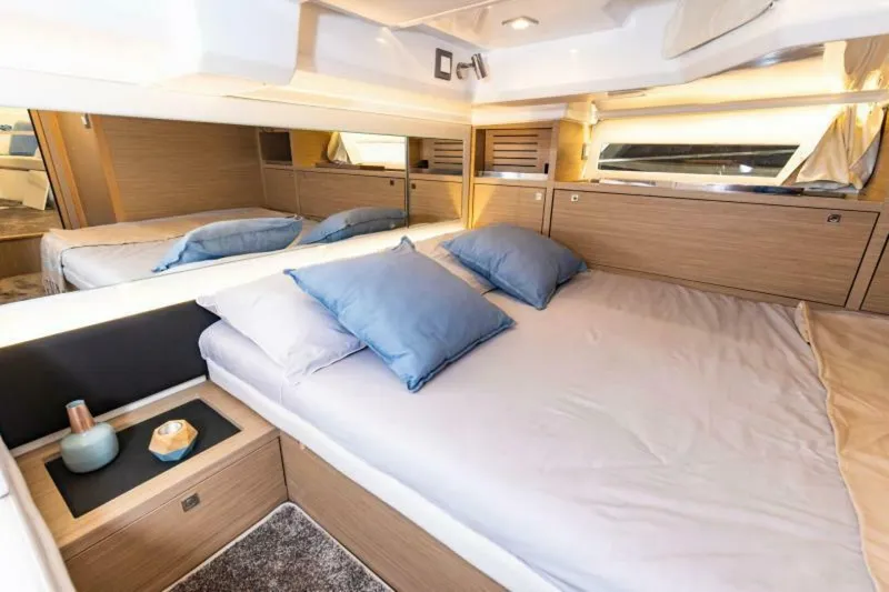  Yacht Photos Pics Luxurious cabin interior of 2024 Jeanneau 10.5 WALK, featuring a cozy bed and modern decor.