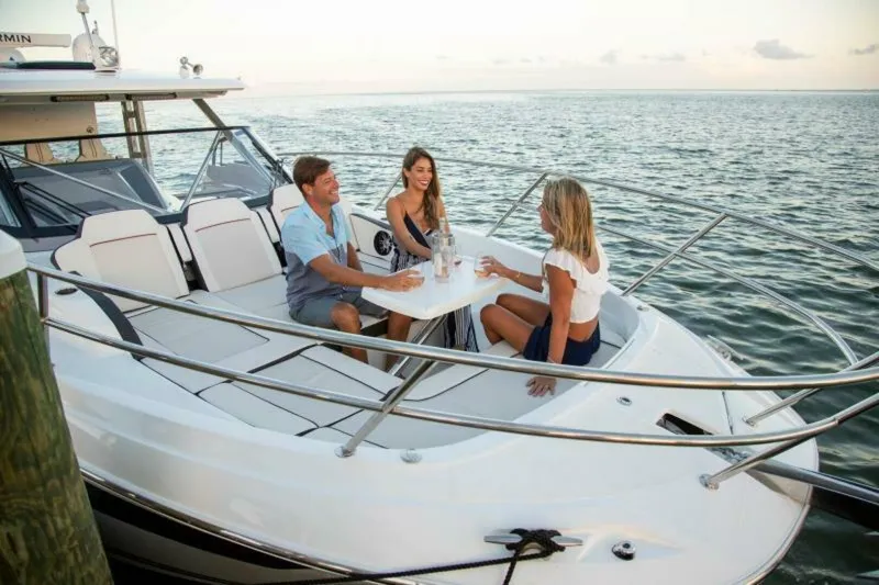  Yacht Photos Pics 2024 Jeanneau 10.5 WALK boat with people enjoying a meal on deck.