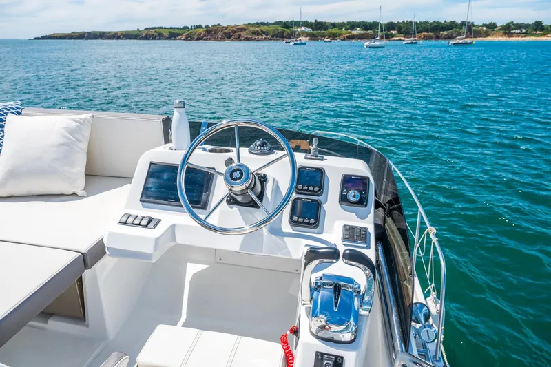  Yacht Photos Pics 2026 Beneteau Antares 11 helm with ocean view, featuring modern controls and comfortable seating.