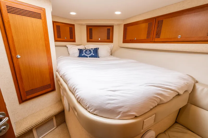 Dieguito Yacht Photos Pics Luxurious cabin interior of 2004 Cabo 48 Flybridge yacht with cozy bed and wooden cabinets.