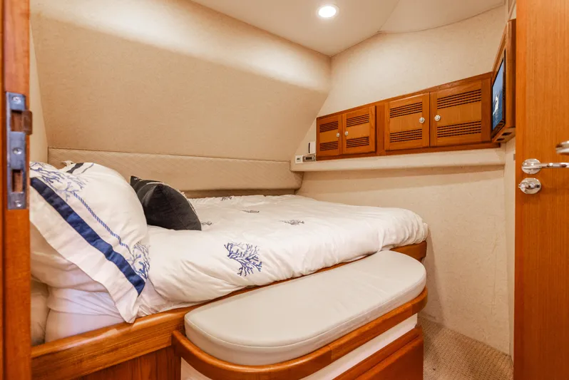 Dieguito Yacht Photos Pics Luxurious cabin interior of 2004 Cabo 48 Flybridge yacht with cozy bedding and wooden accents.