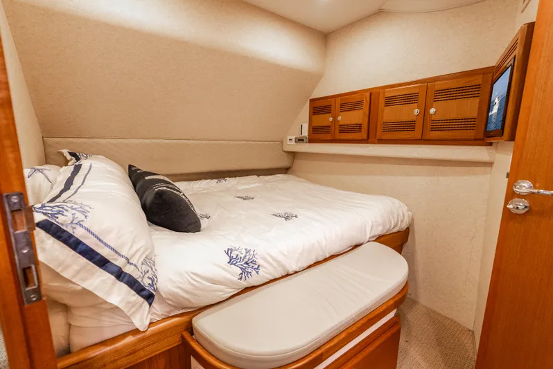 Dieguito Yacht Photos Pics Luxurious cabin interior of 2004 Cabo 48 Flybridge yacht with cozy bed and wooden storage.