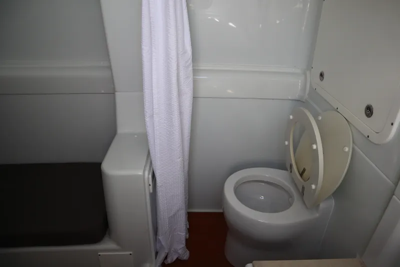  Yacht Photos Pics 2022 Yellowfin 42 Offshore boat bathroom with toilet and shower curtain.