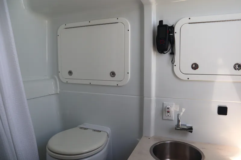  Yacht Photos Pics 2022 Yellowfin 42 Offshore boat bathroom with toilet, sink, and storage compartments.