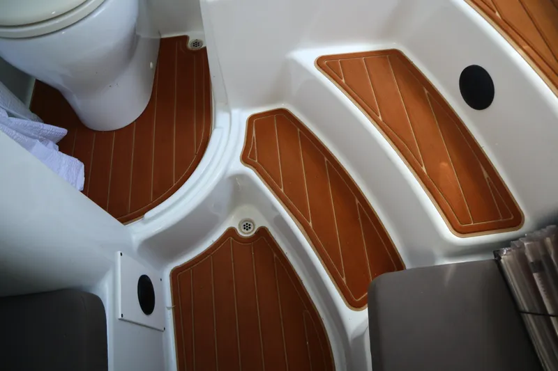  Yacht Photos Pics 2022 Yellowfin 42 Offshore boat interior with teak-style flooring and compact toilet.