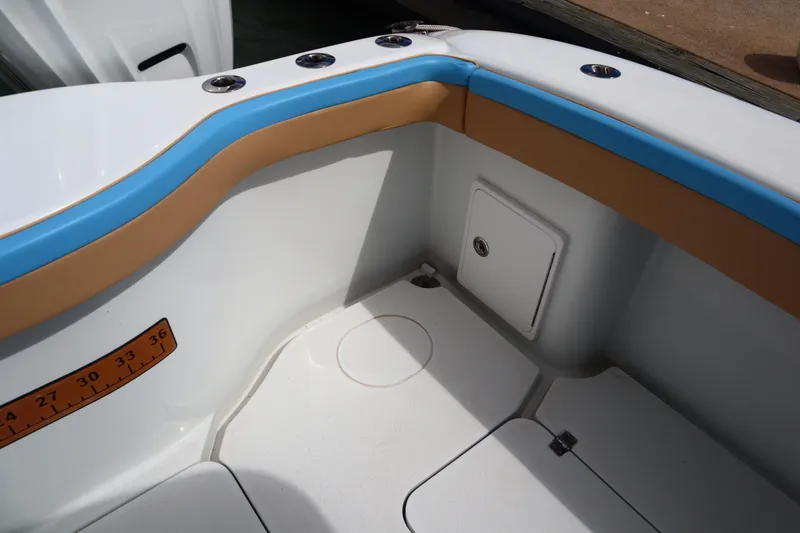  Yacht Photos Pics 2022 Yellowfin 42 Offshore boat interior with blue and tan accents, featuring a storage compartment.