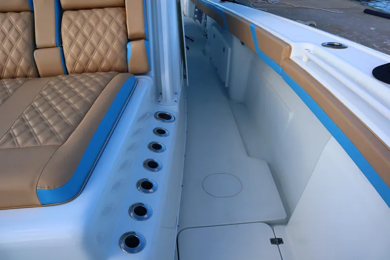  Yacht Photos Pics 2022 Yellowfin 42 Offshore boat interior with tan and blue seating, rod holders, and deck view.