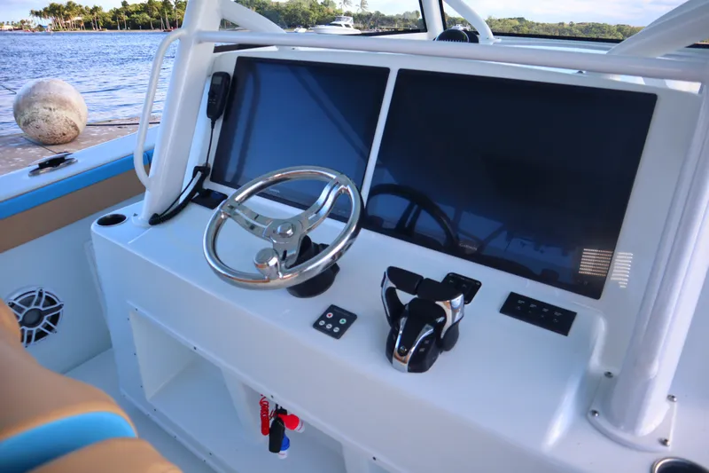  Yacht Photos Pics 2022 Yellowfin 42 Offshore boat dashboard with dual screens and steering wheel.
