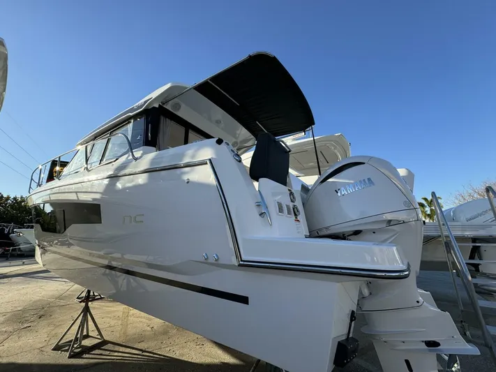  Yacht Photos Pics 2025 Jeanneau NC 1095 Weekender boat with Yamaha engine, docked under clear blue sky.