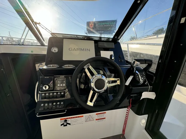  Yacht Photos Pics 2025 Jeanneau NC 1095 Weekender helm with Garmin navigation system and modern controls.