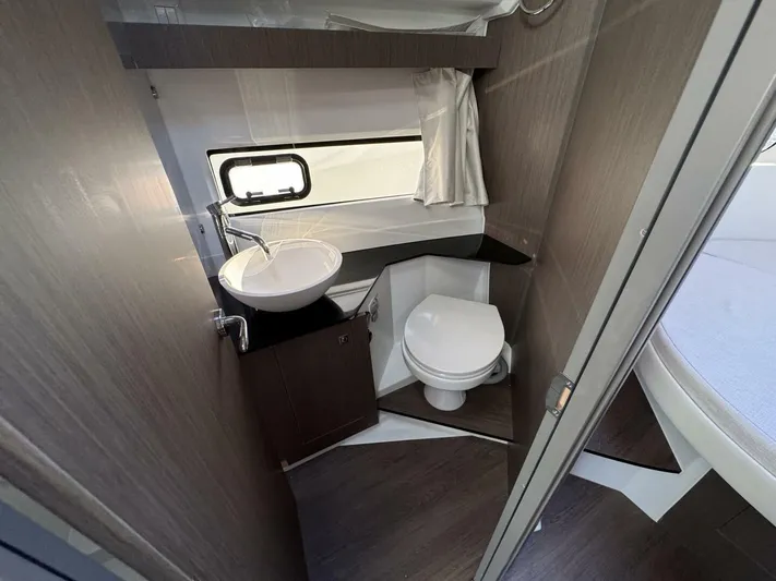  Yacht Photos Pics 2025 Jeanneau NC 1095 Weekender bathroom with modern sink, toilet, and window.