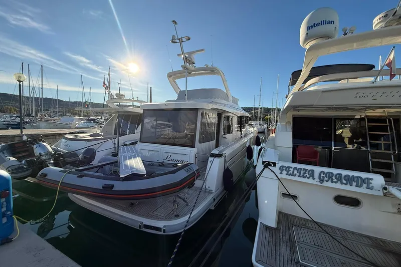 Gbtt Ex Lennartz Yacht Photos Pics Nimbus 495 Flybridge 2025 yacht docked at marina, surrounded by other boats under a sunny sky.