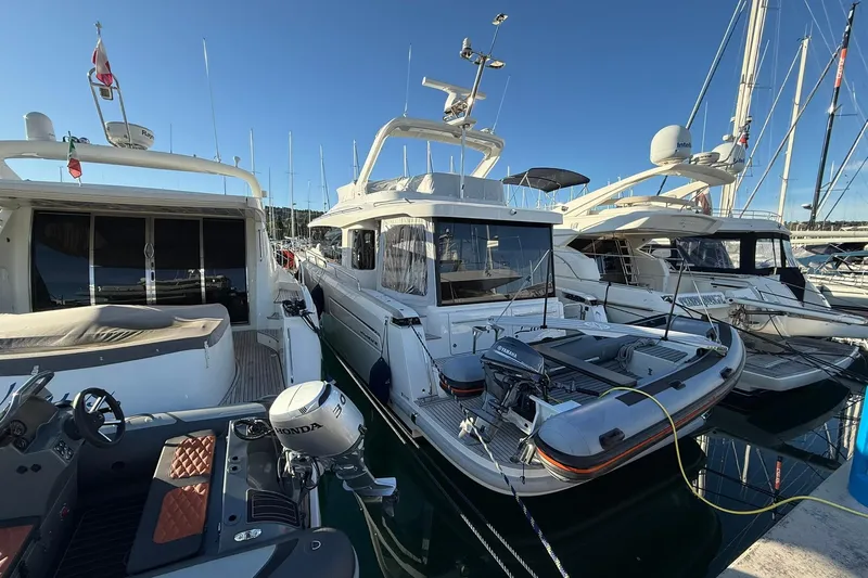 Gbtt Ex Lennartz Yacht Photos Pics 2025 Nimbus 495 Flybridge yacht docked in a marina, surrounded by other boats.