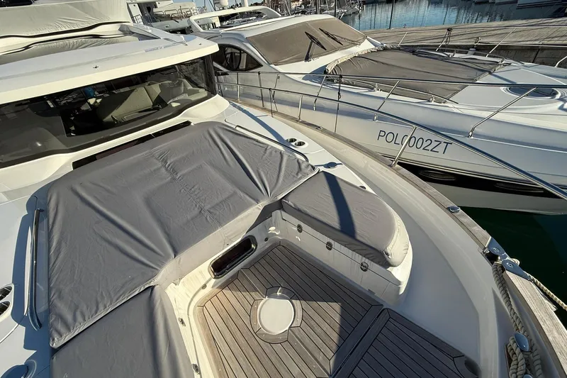 Gbtt Ex Lennartz Yacht Photos Pics 2025 Nimbus 495 Flybridge yacht docked, featuring sleek design and covered seating area.