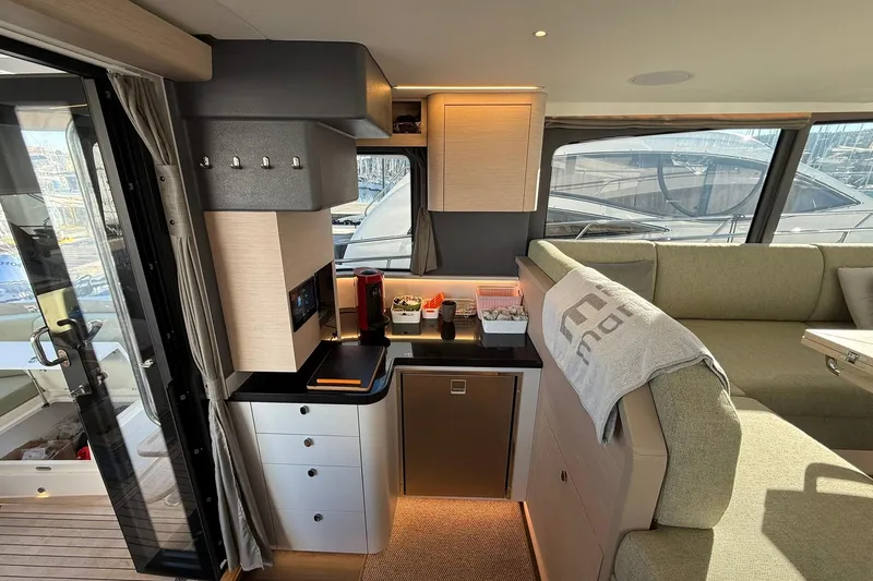 Gbtt Ex Lennartz Yacht Photos Pics Luxurious interior of 2025 Nimbus 495 Flybridge yacht with modern kitchenette and seating area.