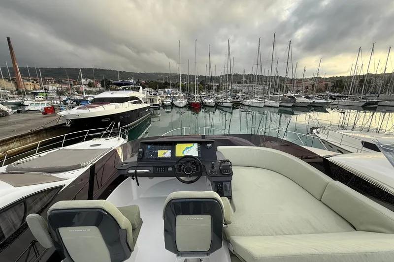 Gbtt Ex Lennartz Yacht Photos Pics Flybridge view of 2025 Nimbus 495 yacht docked in a marina under cloudy skies.